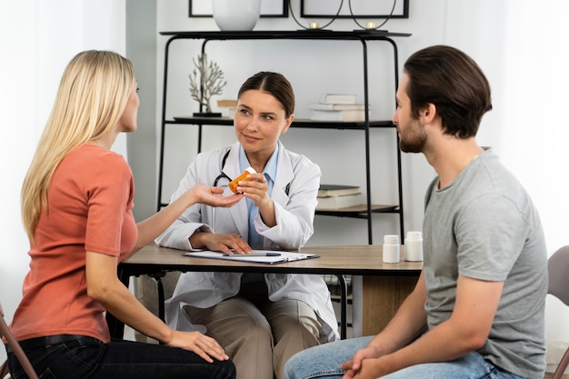 Side view young couple talking to doctor