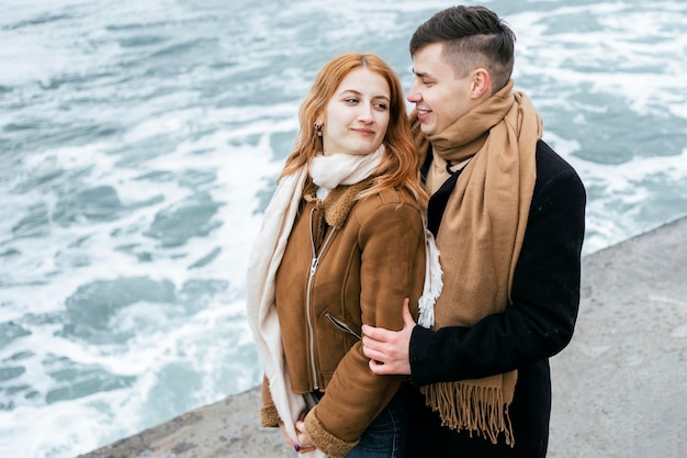 Side view of young couple in winter outdoors