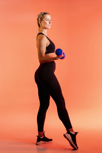 Free photo side view young female training with weights