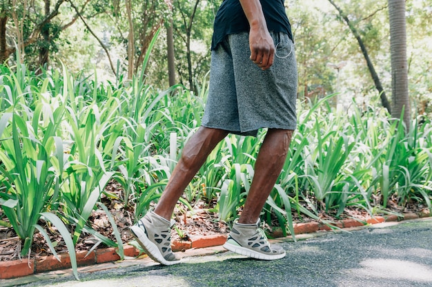 Side view of a young male athlete running in the park