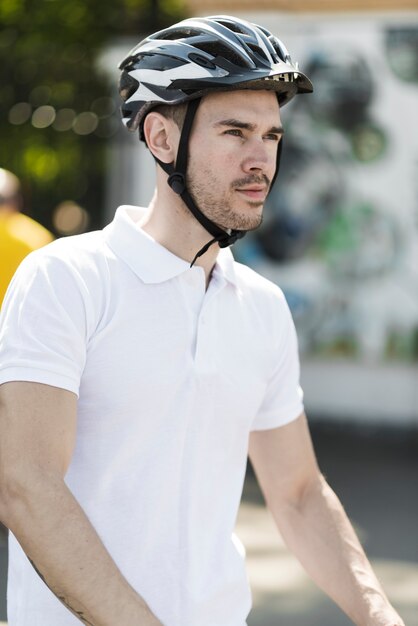 保護ヘルメットを持つ若い男性のサイクリストの側面図