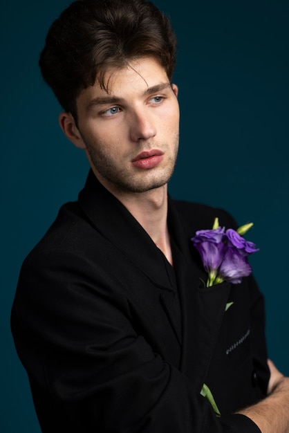 Free photo side view young man holding purple flower