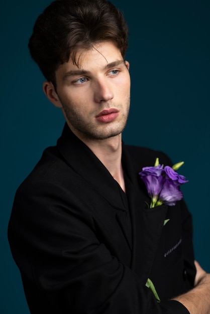 Side view young man holding purple flower