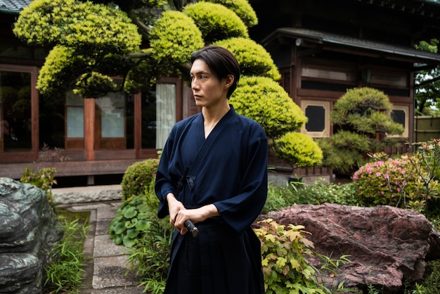 Side view young man holding samurai sword