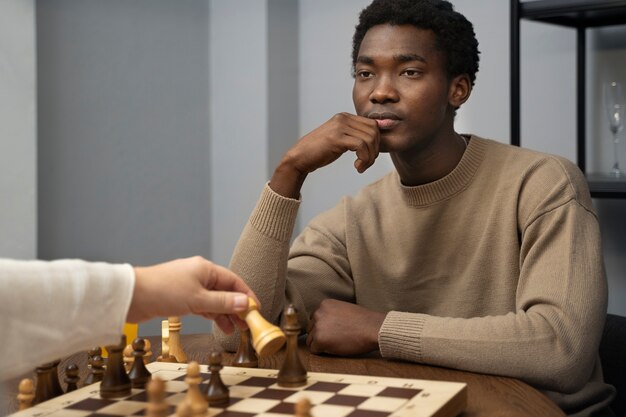 Side view young man playing chess