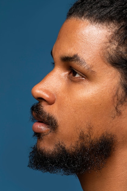 Free photo side view young man posing in studio