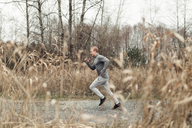 Side view of young man running in field