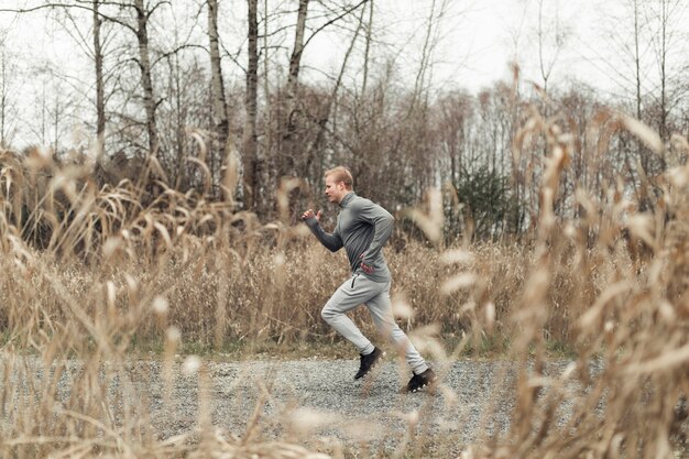 Side view of young man running in field