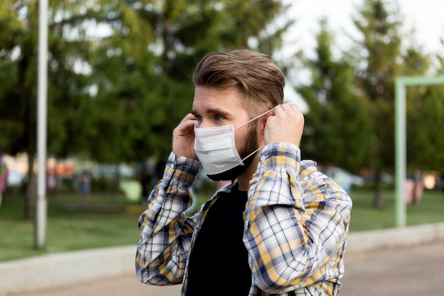 Free photo side view young man wearing face mask