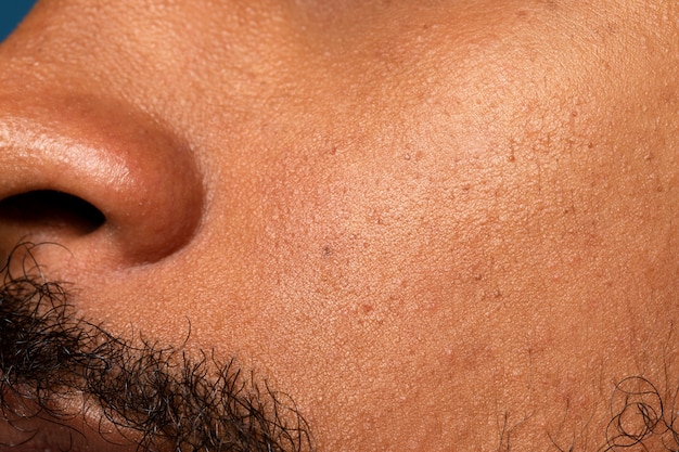 Free photo side view young man with beard skin texture