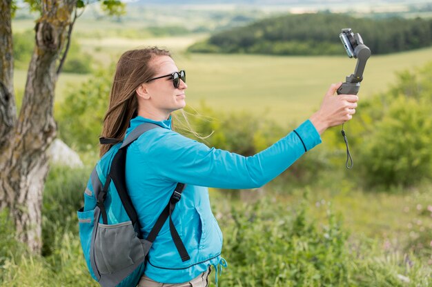 サイドビュー若い旅行者が屋外でselfieを取る