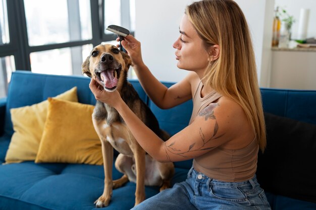 犬をブラッシングする側面図の若い女性