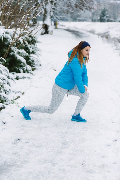 Free photo side view of young woman doing exercise in winter