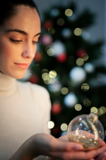 Side view young woman holding christmas globe
