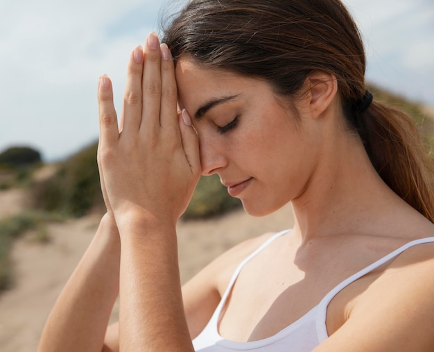 Free photo side view young woman meditating