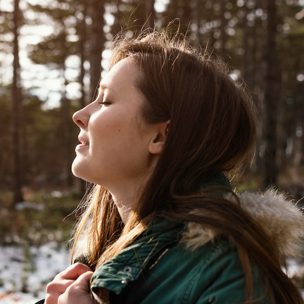 Free photo side view young woman in nature