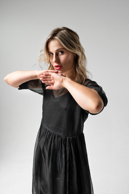 Free photo side view young woman posing in black dress