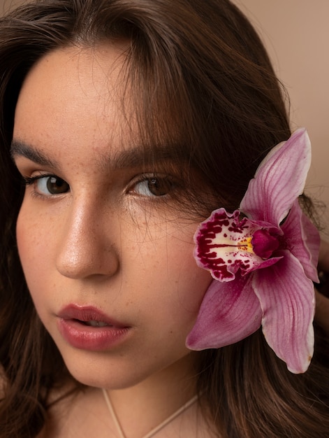 Free photo side view young woman posing with flower