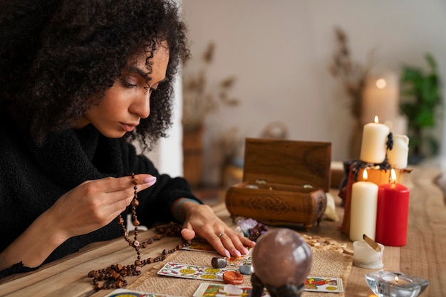 Foto gratuita tarocchi della lettura della giovane donna di vista laterale