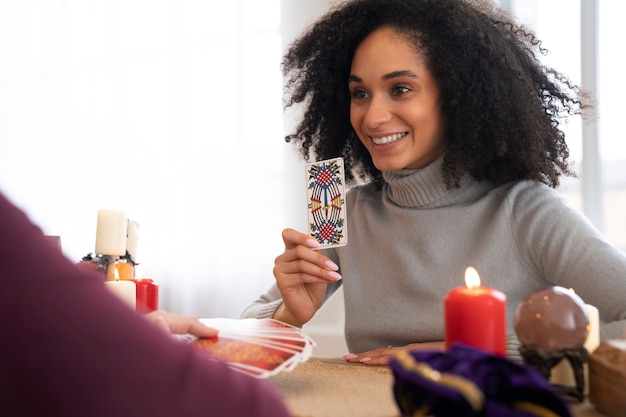 Free photo side view young woman reading tarot