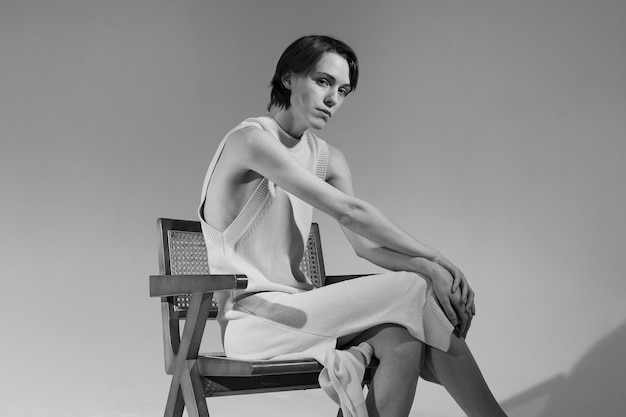 Side view young woman sitting on chair black and white