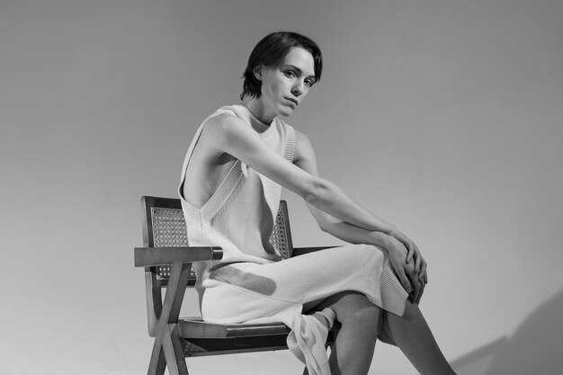 Side view young woman sitting on chair black and white