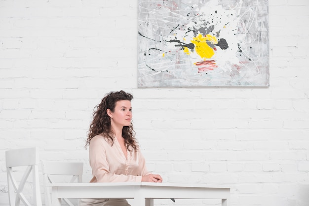 Side view of young woman sitting on dining table