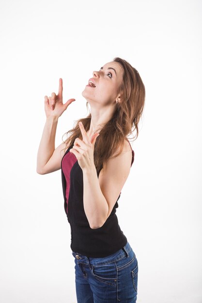 Side view of a young woman standing against white background looking up