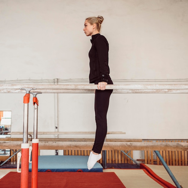 Foto gratuita vista laterale della giovane donna di formazione per il campionato di ginnastica