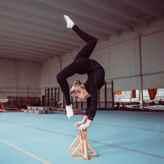 Free photo side view young woman training on wooden pieces