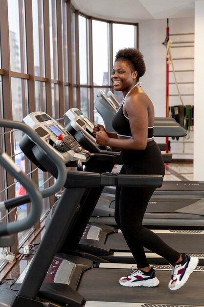 Side view young woman on treadmill