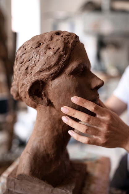 Free photo sided view hands clay sculpting