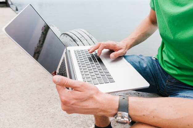 Sideview man working on laptop