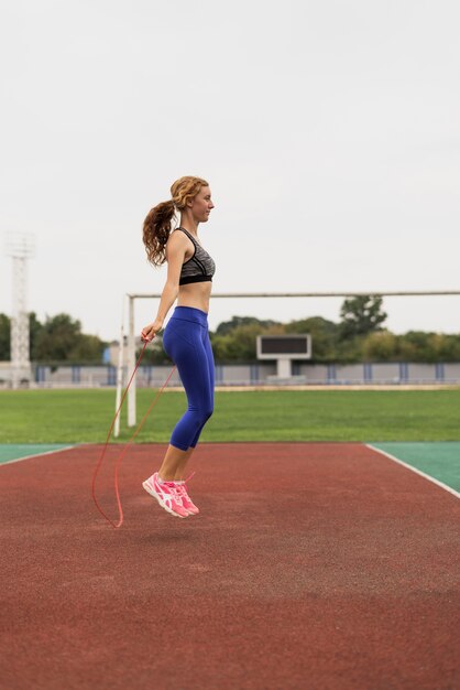 Sideway beautiful woman jumping rope