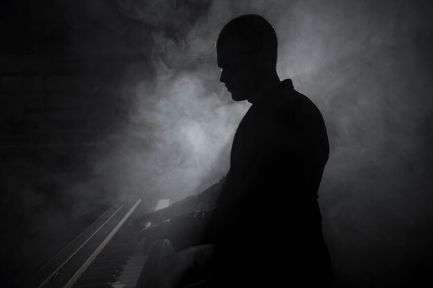 Sideways artist playing piano smoke and shadows effects