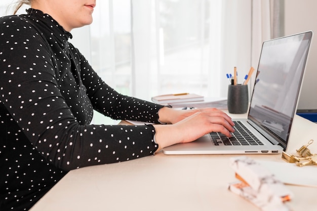 Free photo sideways business woman working on laptop