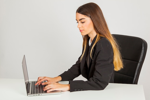 Free photo sideways businesswoman typing