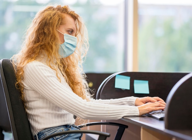 Sideways businesswoman wearing medical mask