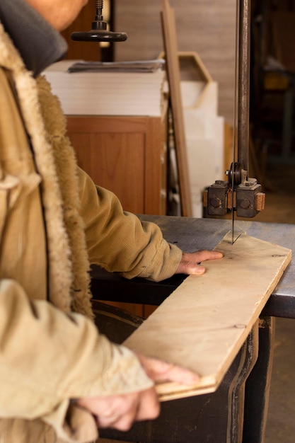 Foto gratuita falegname lateralmente che lavora alla lavorazione del legno