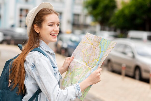 Sideways city traveller holding a map