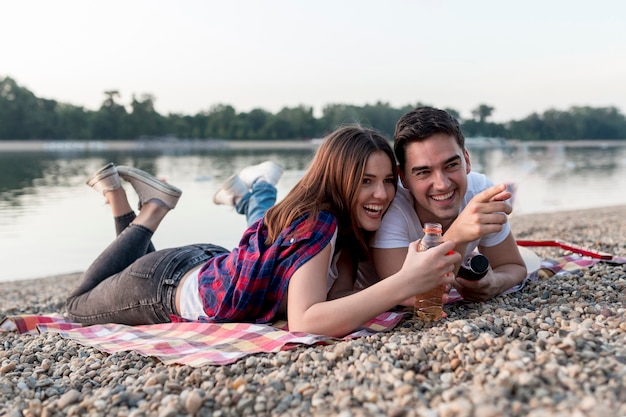 Sideways couple on a date lying on picnic blanket