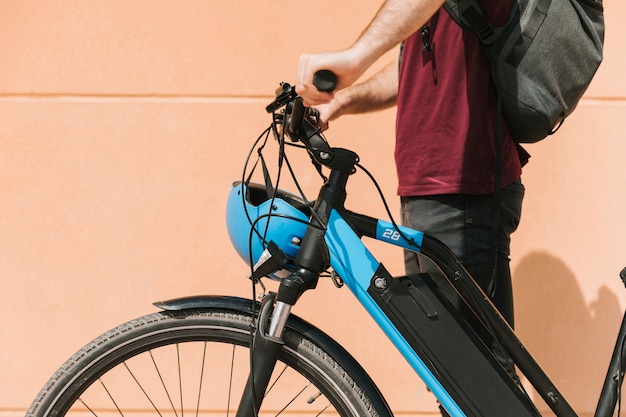 Foto gratuita ciclista lateralmente in piedi accanto alla e-bike