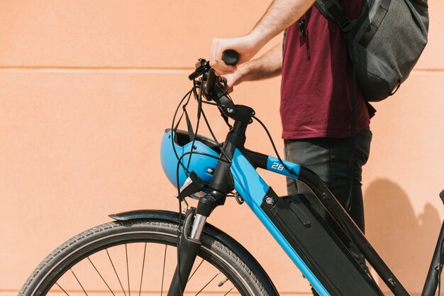 Боковой велосипедист стоит рядом с электронным велосипедом
