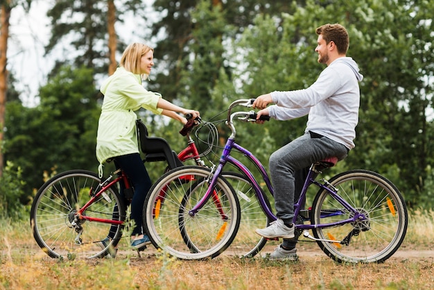 Сбоку счастливая пара на велосипедах