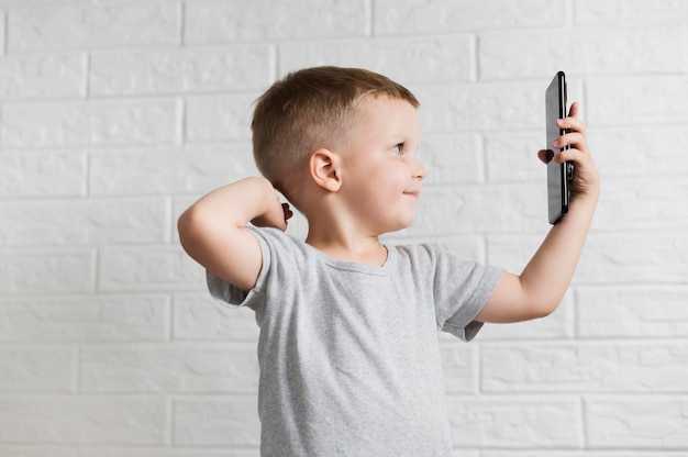 Sideways little boy taking a selfie