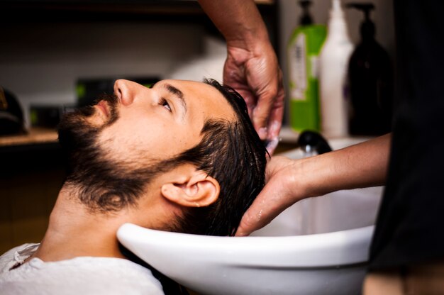 Sideways man getting a hair wash