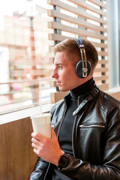 Sideways man listening to music on headphones inside