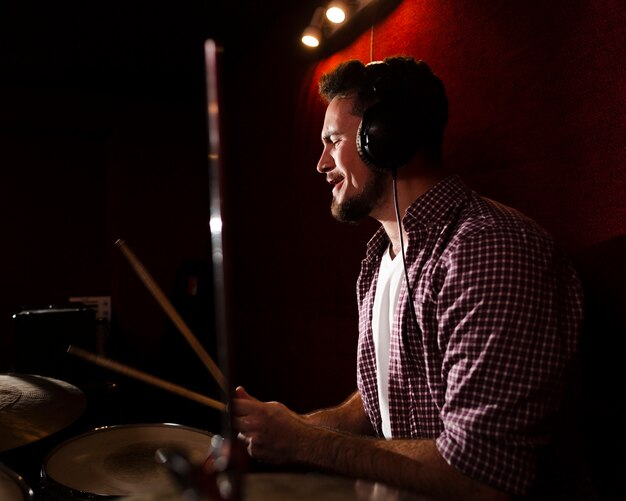 Sideways man playing drums and wearing headphones