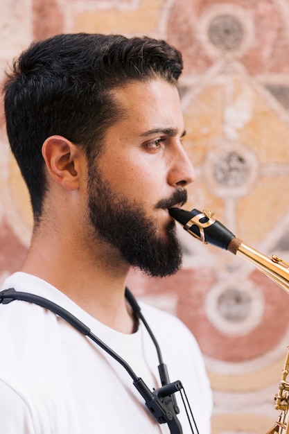 Sideways man portrait playing the saxophone