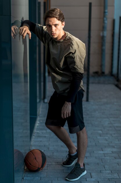 Sideways man posing with a basketball